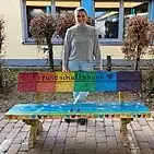 Carolin Hippel hinter der bunt angemalten Freundschaftsbank auf dem Schulhof.