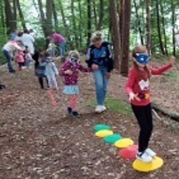 Die Kinder erproben mit den verbundenen Augen den Vertrauensparcours im Wald.