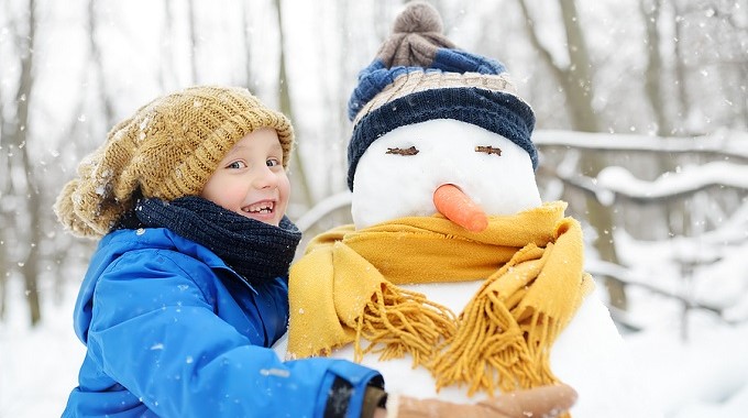 Ein Junge umarmt einen Schneemann.