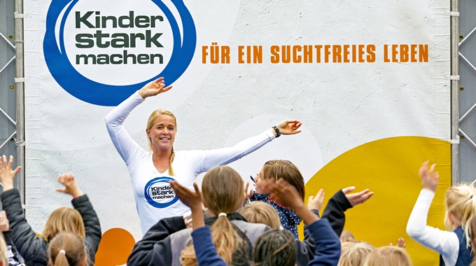 Singa tanzt auf der Aktionsbühne vor vielen Kindern