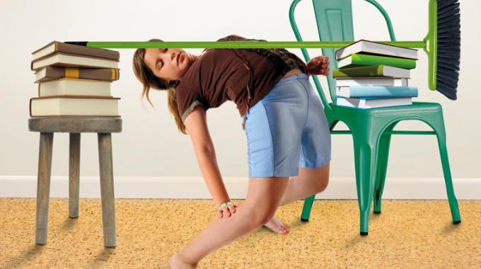 Ein Mädchen versucht Limbo unter einem Besen hindurch