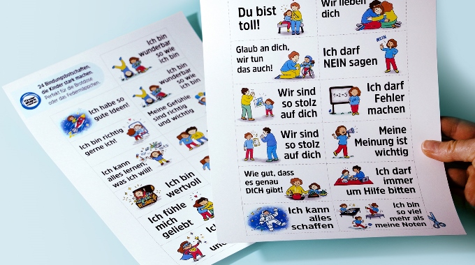 Bild von zwei Papierbögen mit illustrierten Bindungsbotschaften, die Kinder stark machen.