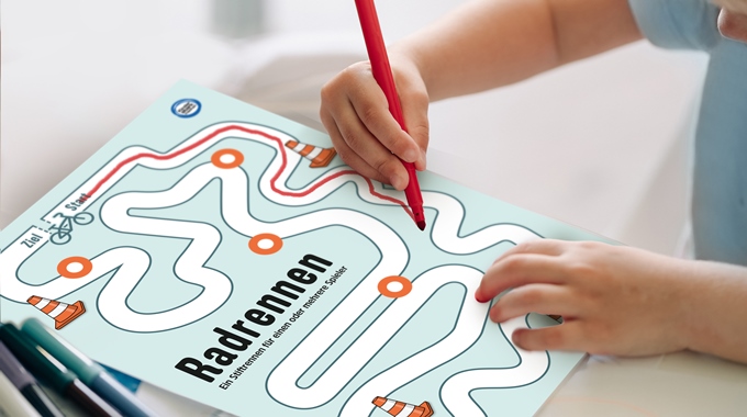 Ansicht der Spielvorlage mit Hand, die mit einem Stift die vorgegebene Strecke „abfährt".